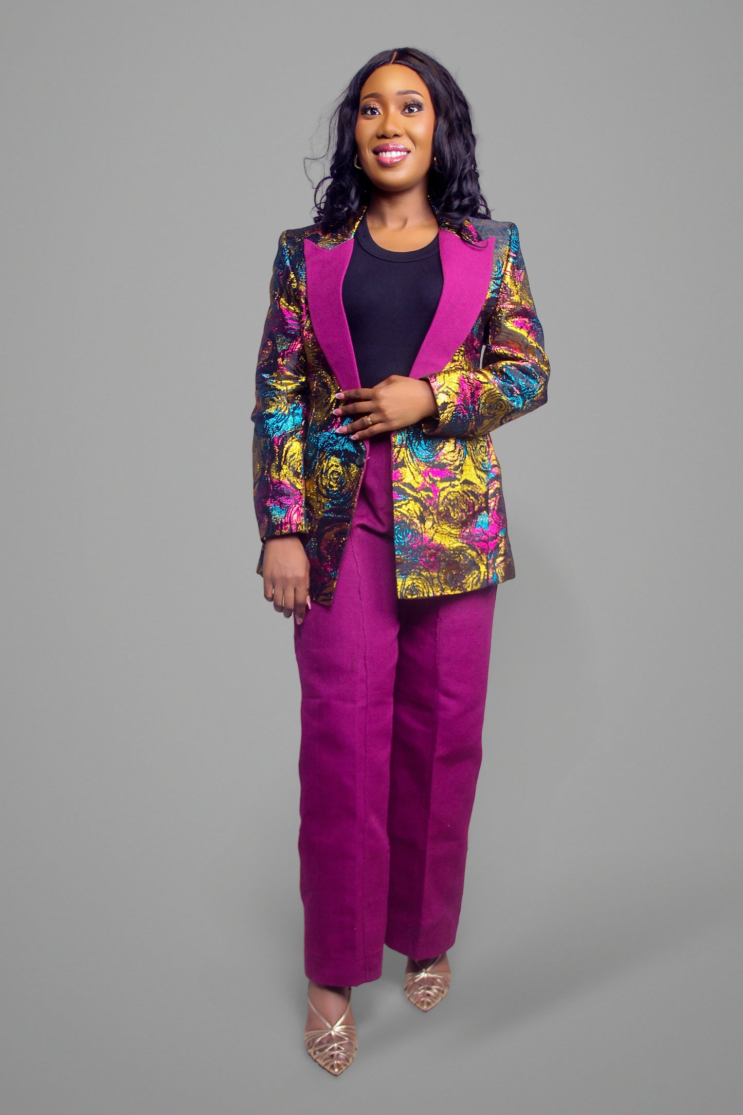 Front view of a tailored two-piece suit featuring a shimmering metallic floral blazer and solid magenta tailored trousers.