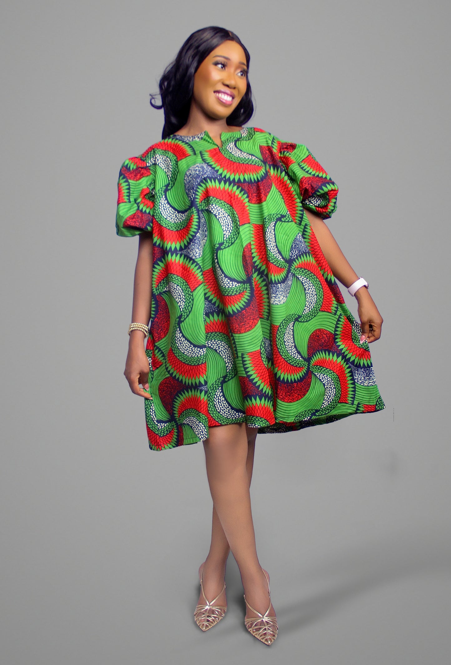 Full length view of a patterned cotton shift dress with puff sleeves against a neutral background
