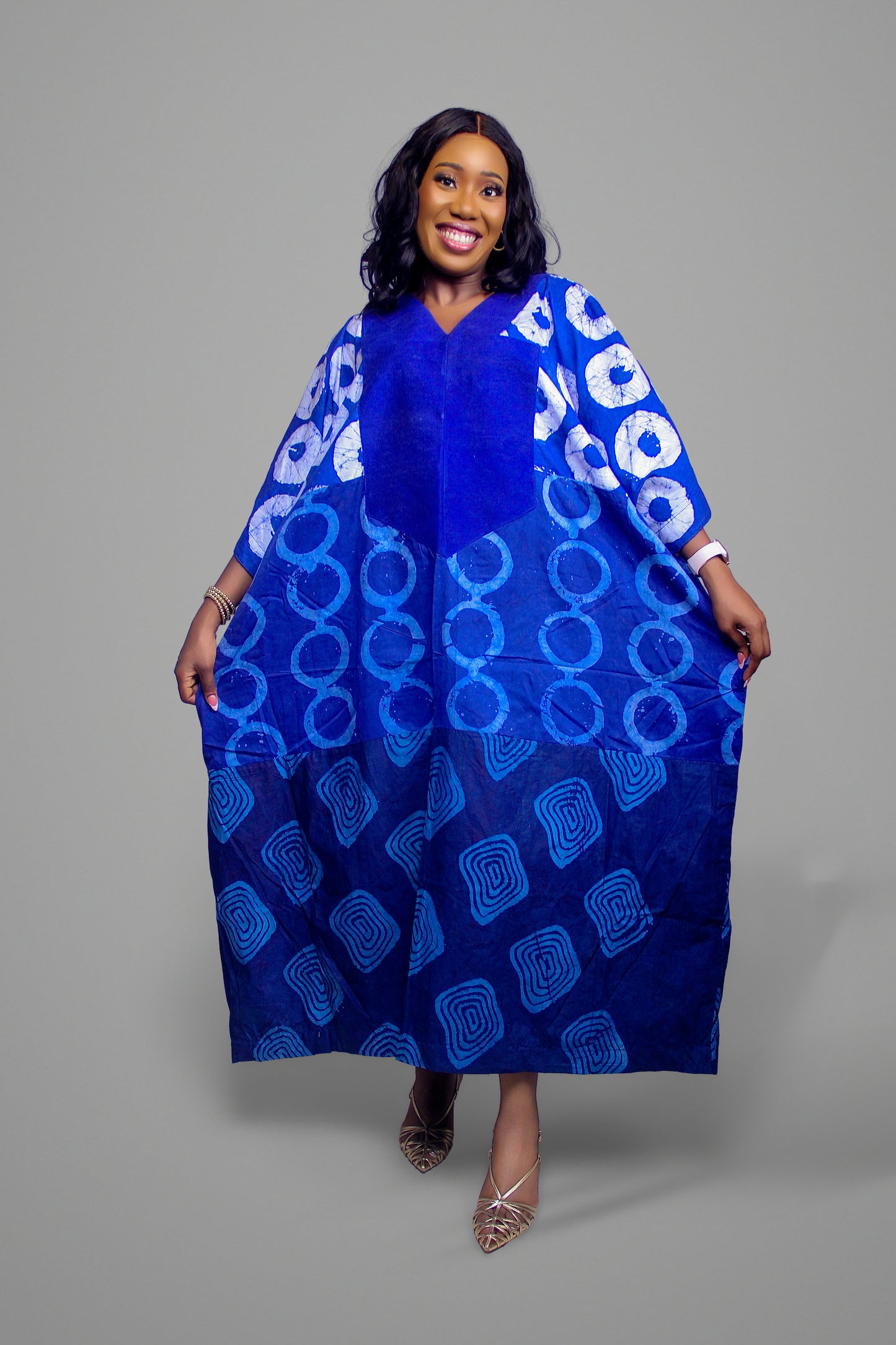Kaftan dress in shades of blue with circular and geometric batik patterns throughout the piece.