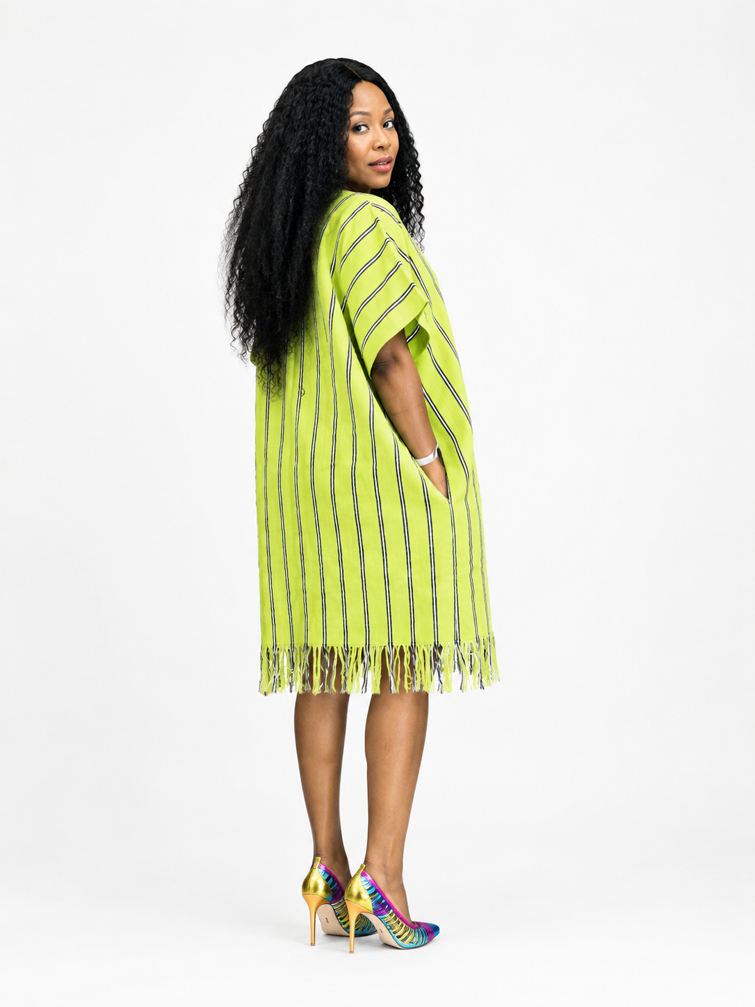 Side view of a lime green kaftan dress with vertical stripes and fringe