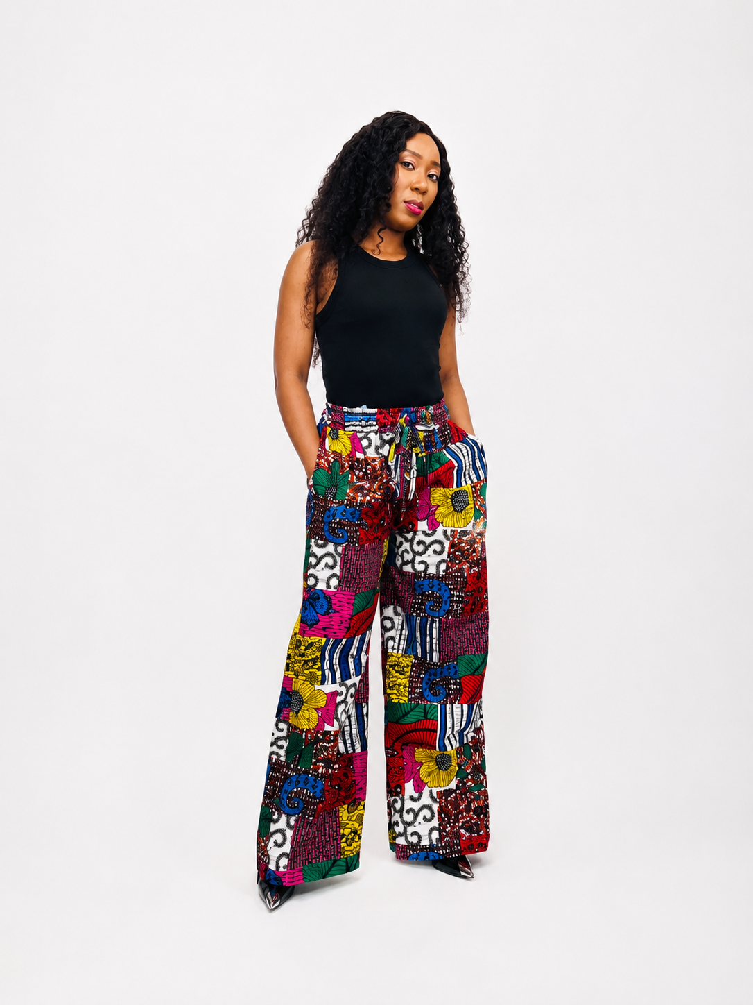A full-length front view of high-waisted wide-leg trousers in a bold, vibrant African print fabric.