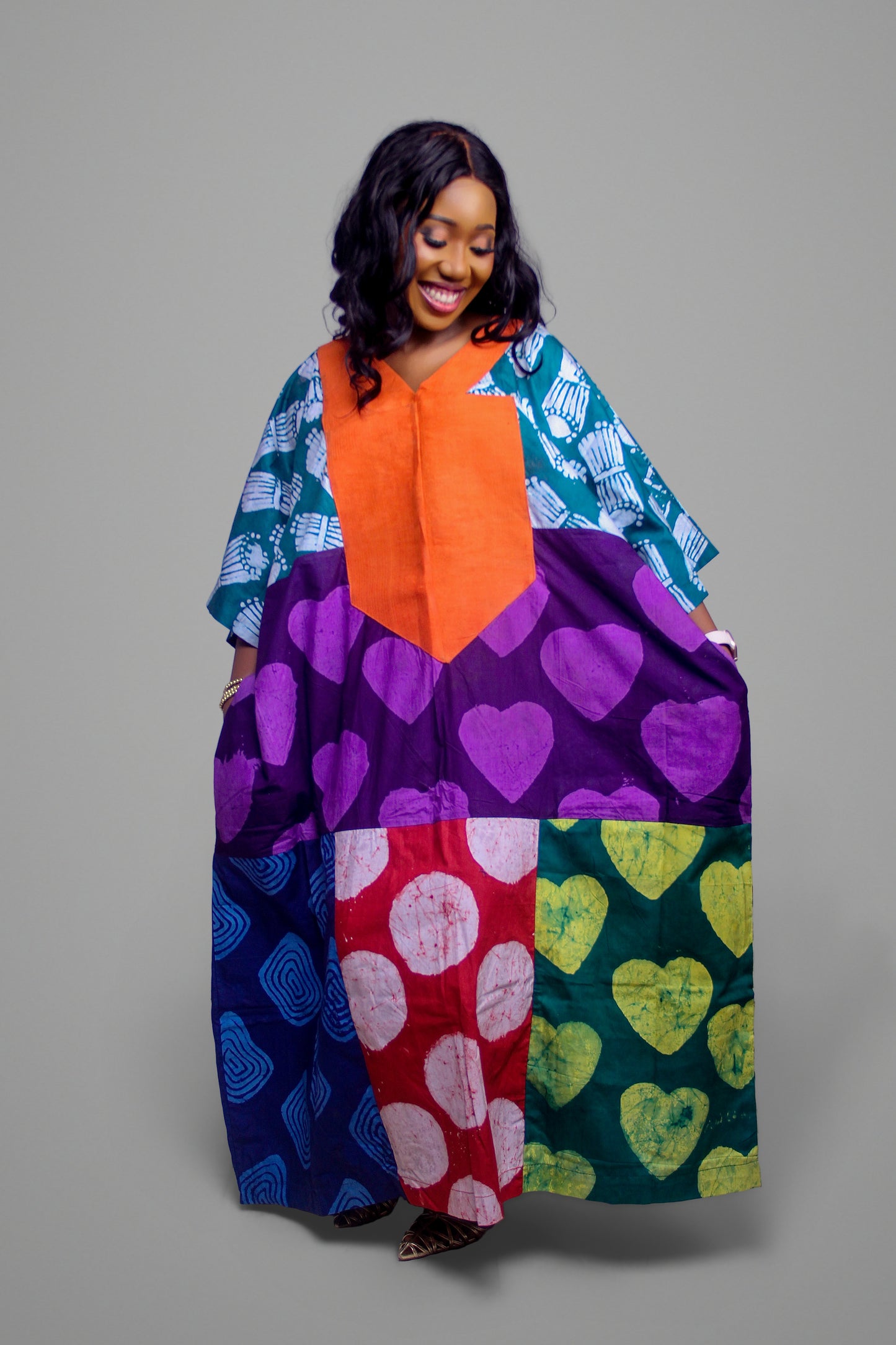 Kaftan dress featuring large orange chest panel, purple heart pattern, and red-white circle motifs.