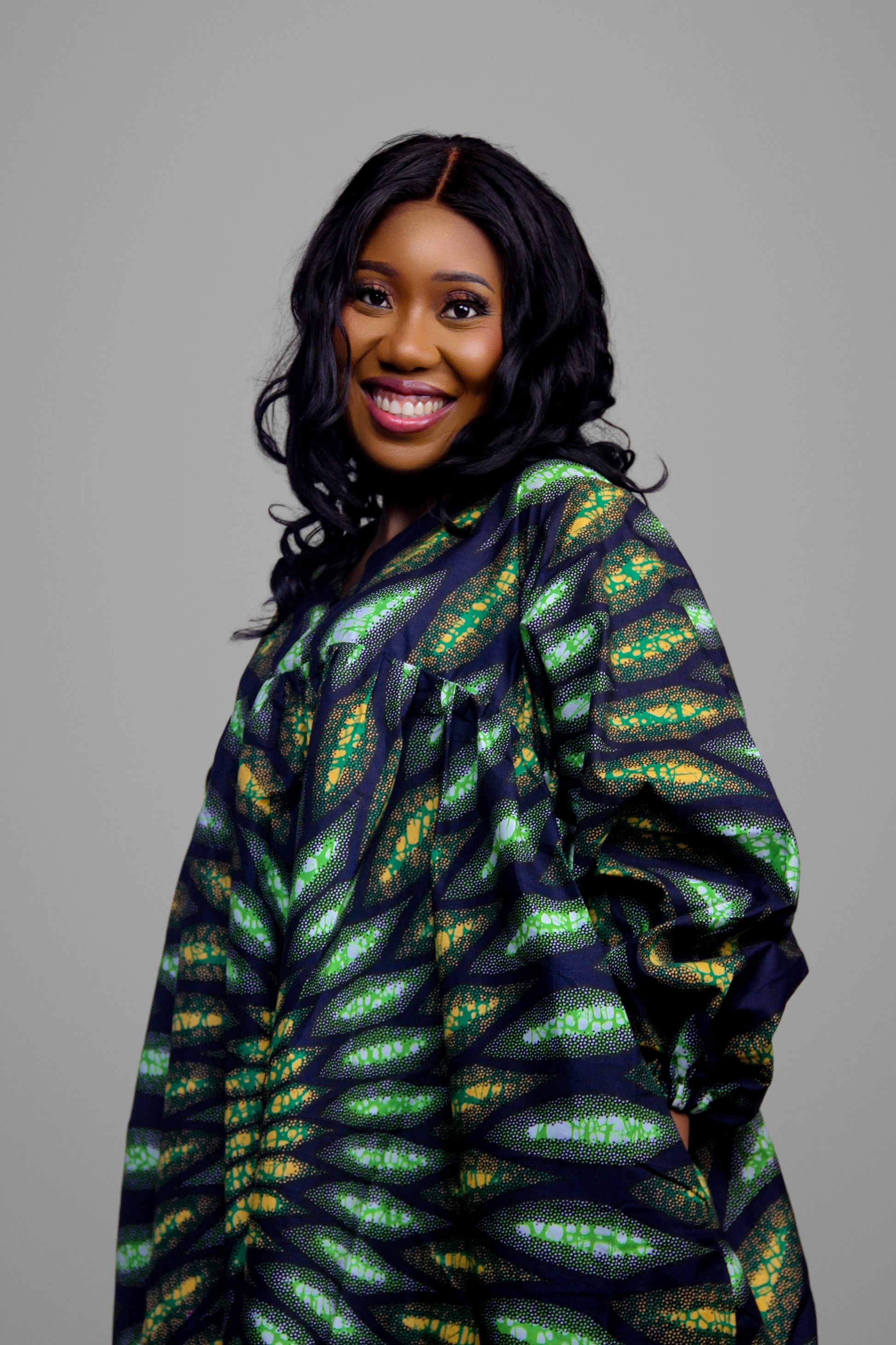 Close-up of the green and yellow concentric petal-like African print pattern on a long sleeve kaftan