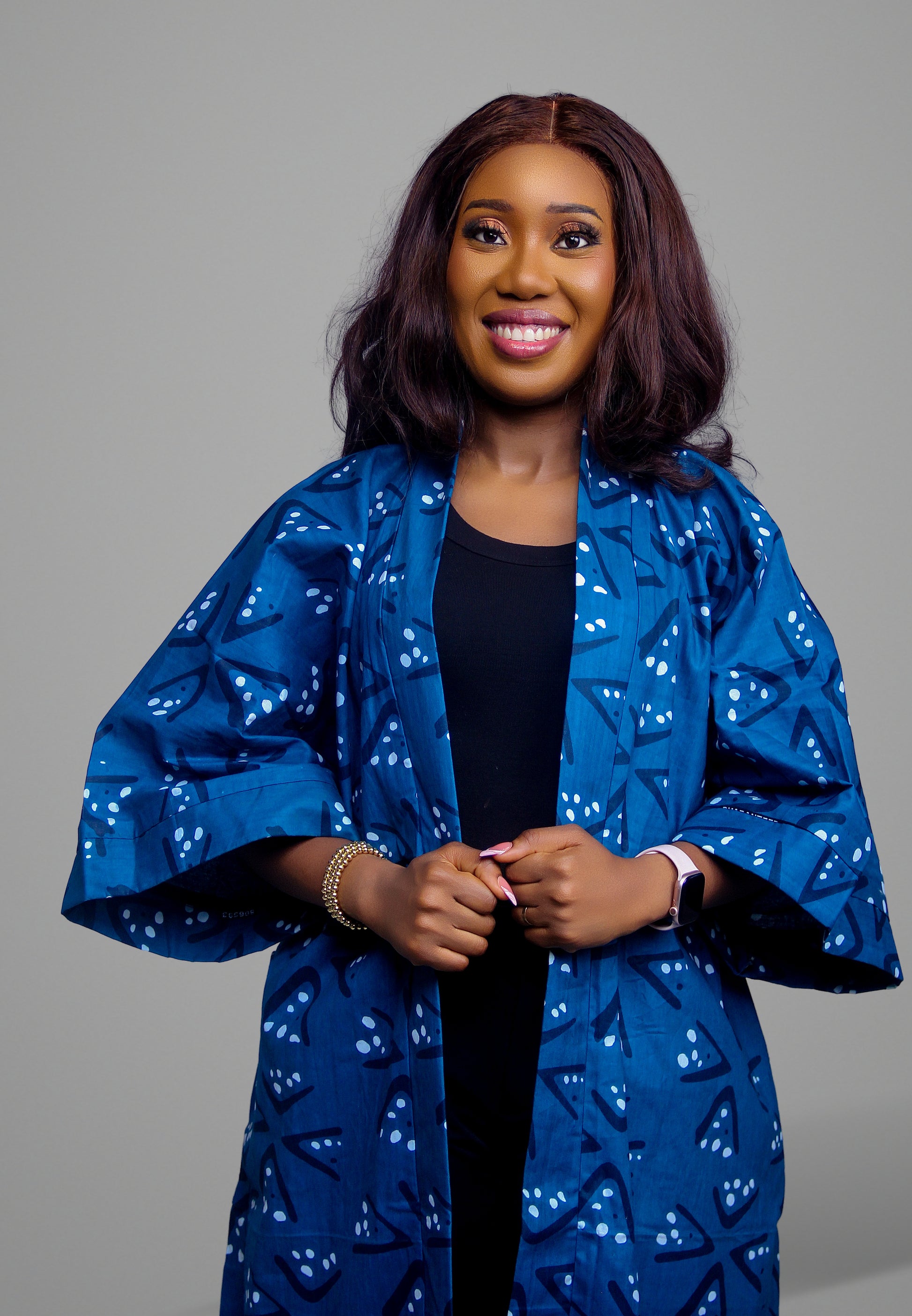 Woman wearing a blue Adire print kimono with geometric patterns and wide sleeves
