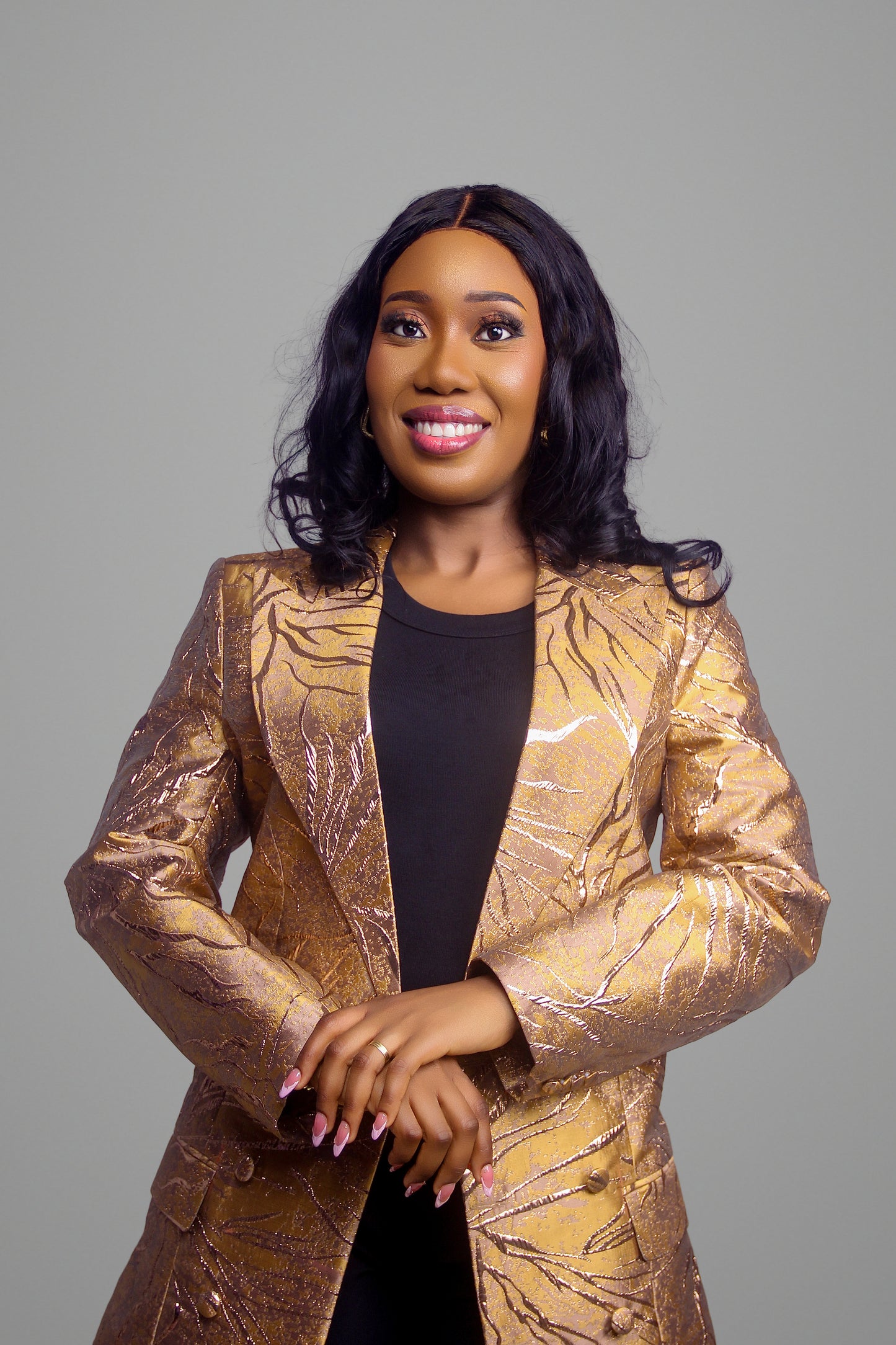 Close up portrait of woman in a gold and red floral brocade blazer