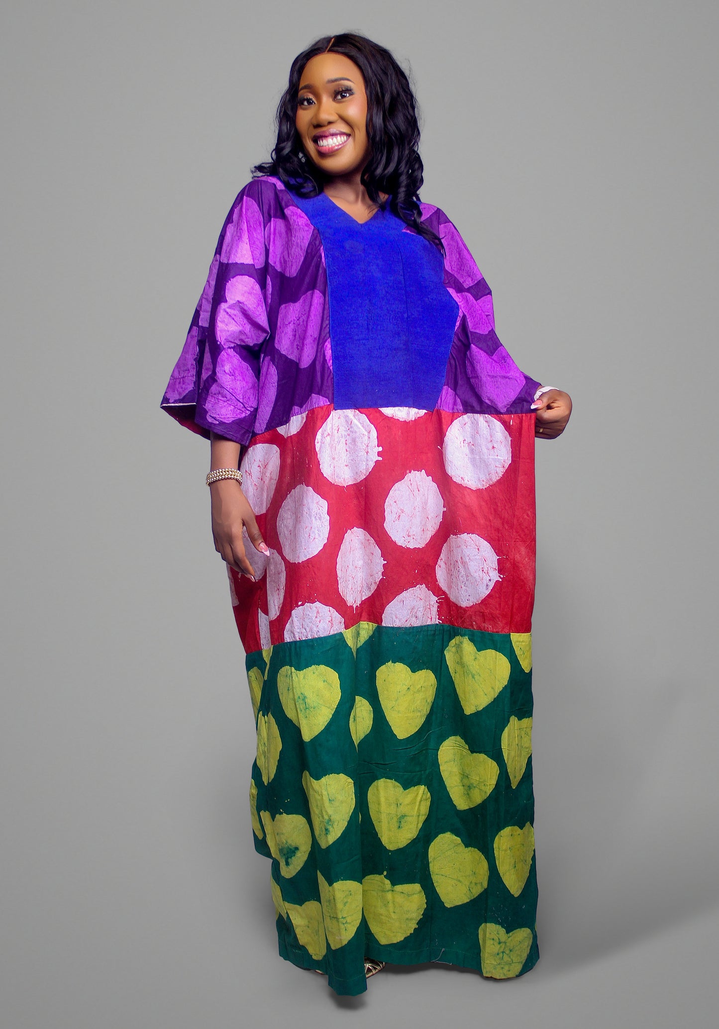 Kaftan dress with a blue chest panel, purple-black upper pattern, and bold red-white-green bottom sections.