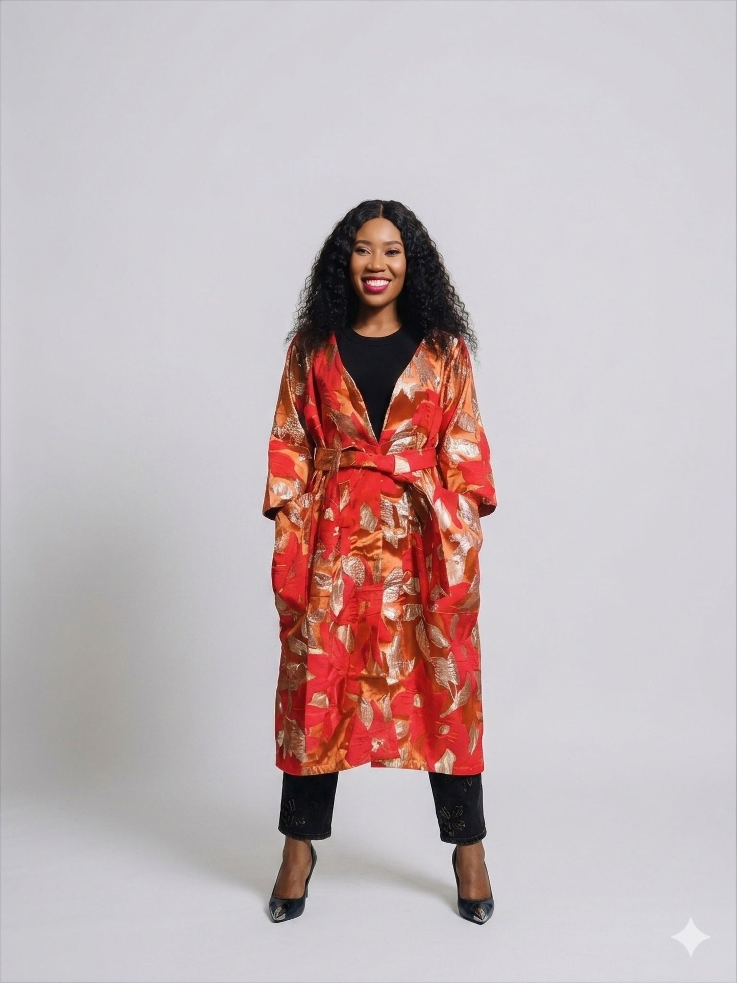 Front view of a woman in a red and gold floral brocade kimono coat, captured in a studio setting.