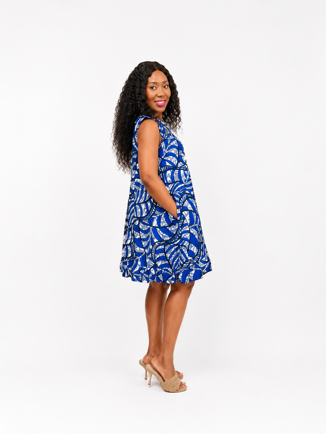 Side view of a blue and white patterned sleeveless shift dress with side pockets