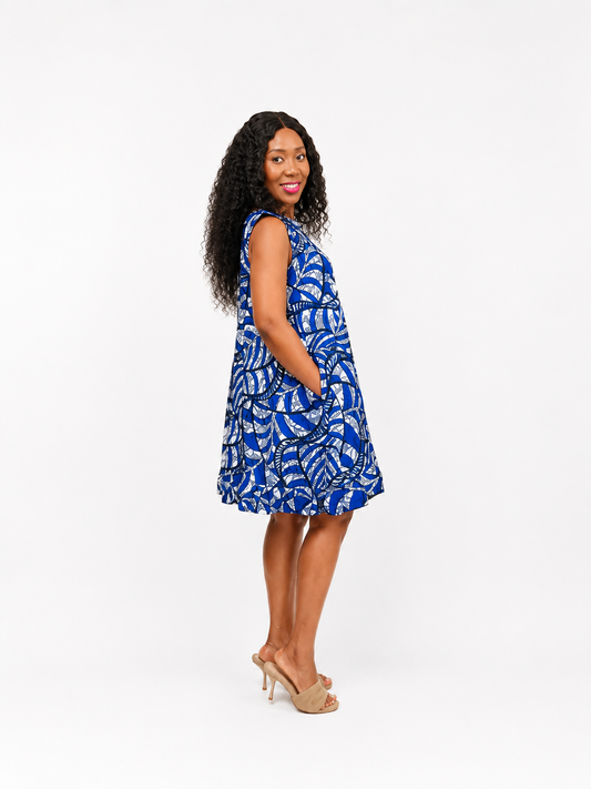 Side view of a blue and white patterned sleeveless shift dress with side pockets