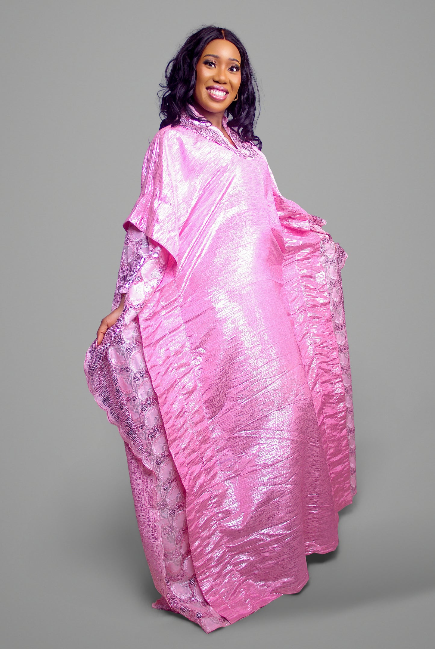 A bright pink kaftan gown with shimmering fabric and embroidered trim.