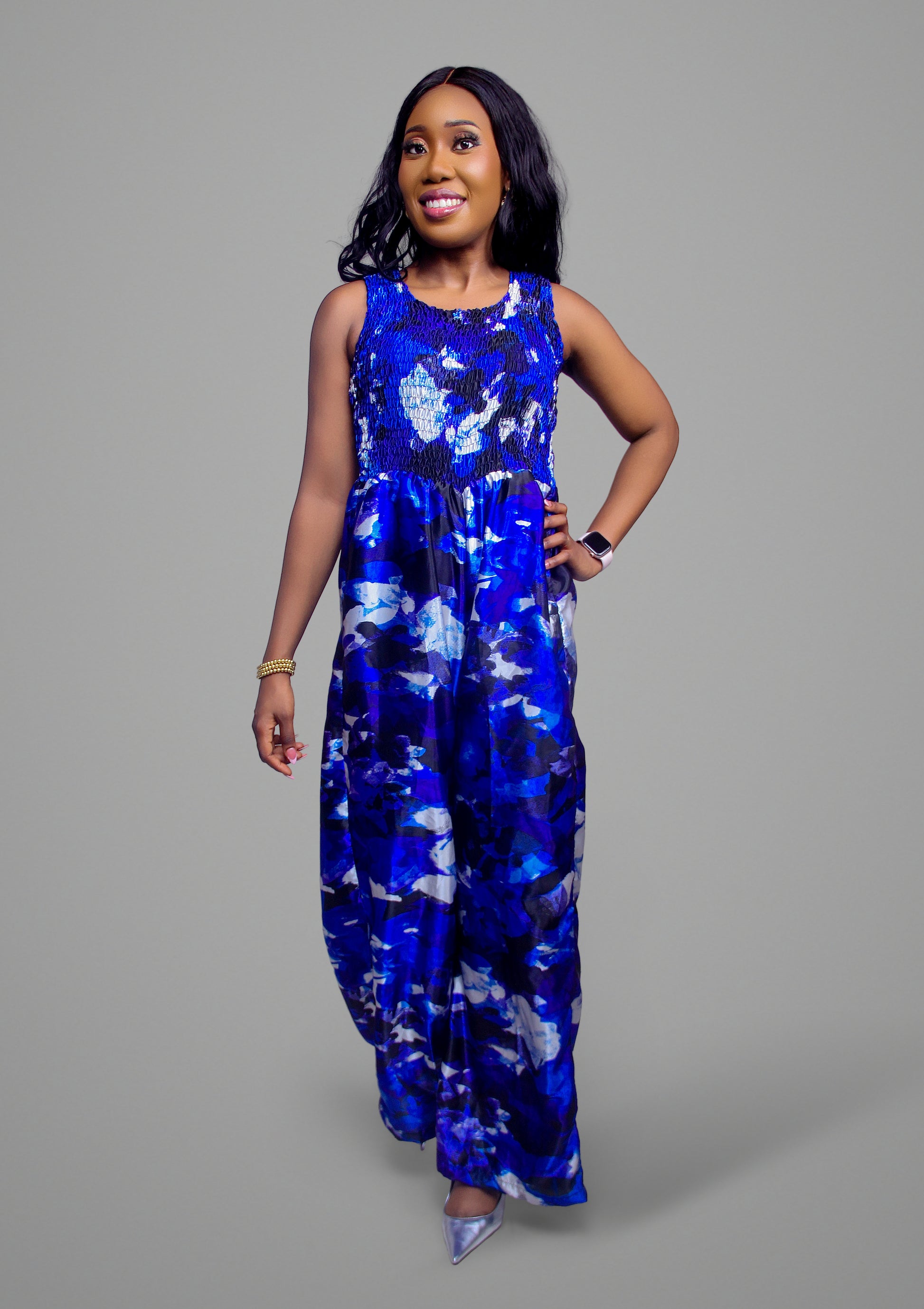 A full-body view of a blue abstract print jumpsuit demonstrating the fluid drape of the wide-leg cut.