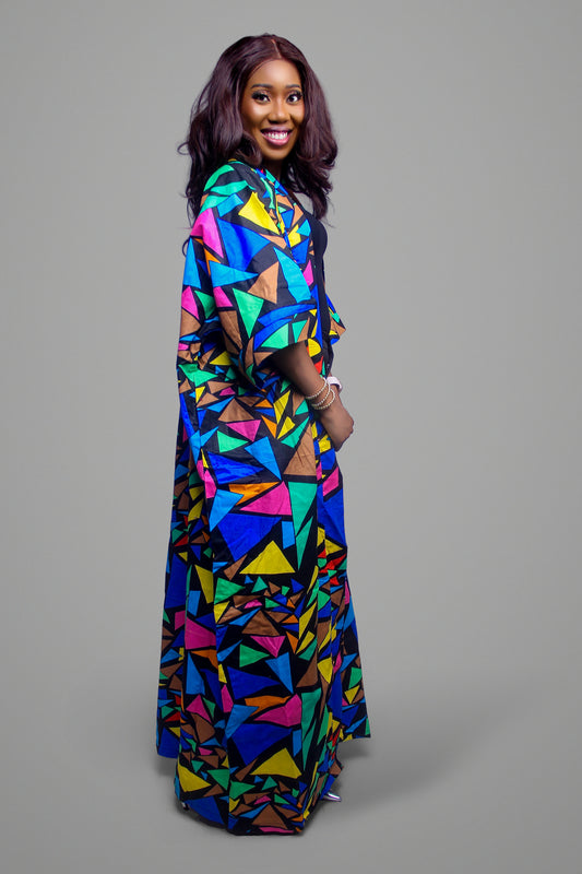 Side profile of a woman wearing a floor-length kimono with a vibrant multi-colored geometric mosaic pattern