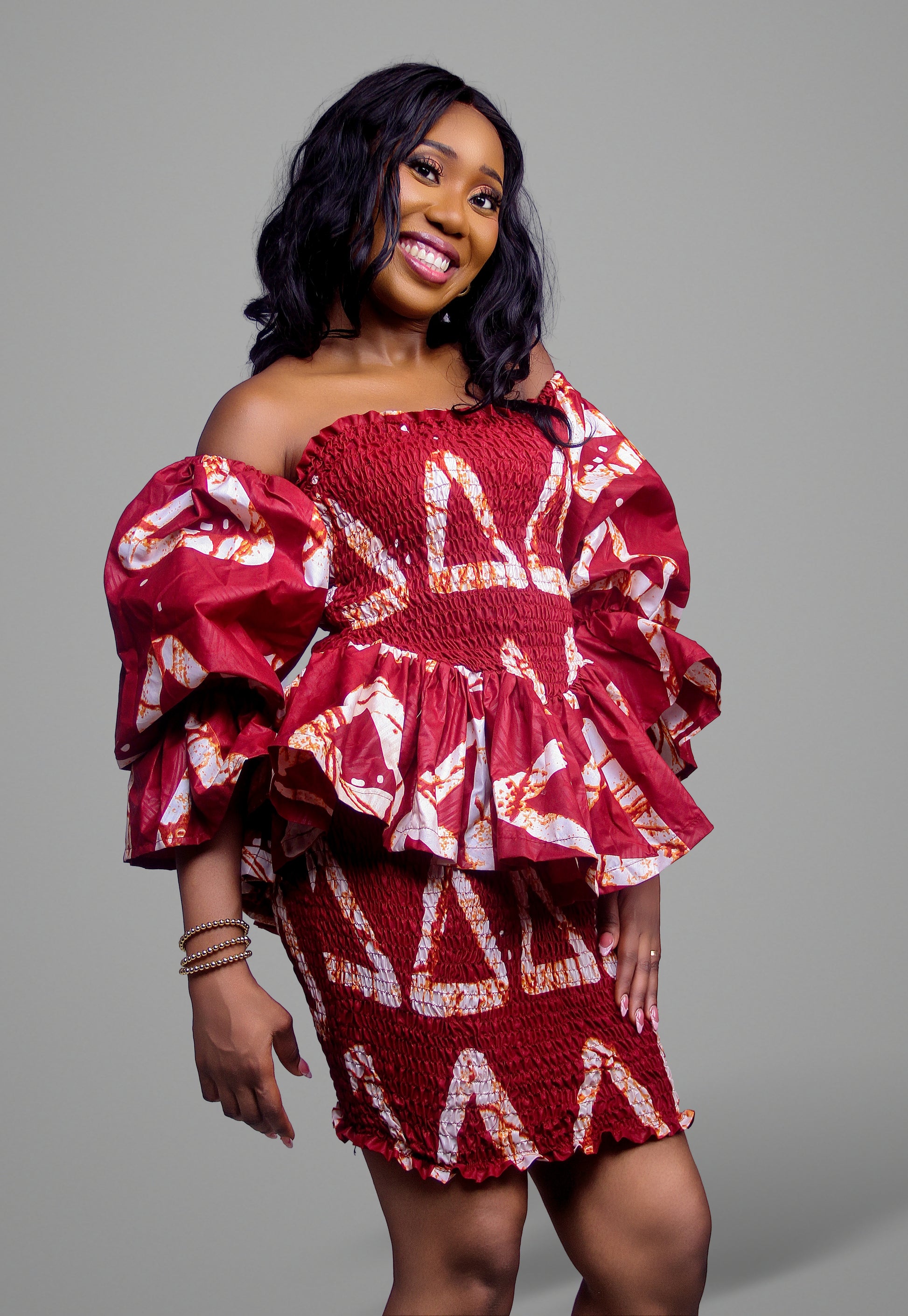 Smocked off-the-shoulder mini dress in a bold red and white geometric batik print