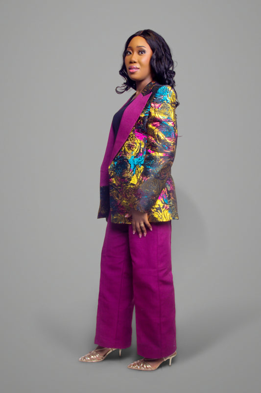 Side profile of a metallic floral brocade blazer in gold, blue, and magenta paired with magenta wide-leg trousers.