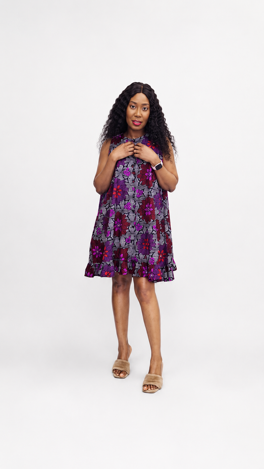 A sleeveless mini dress in a purple and red floral Ankara print with a ruffled hem