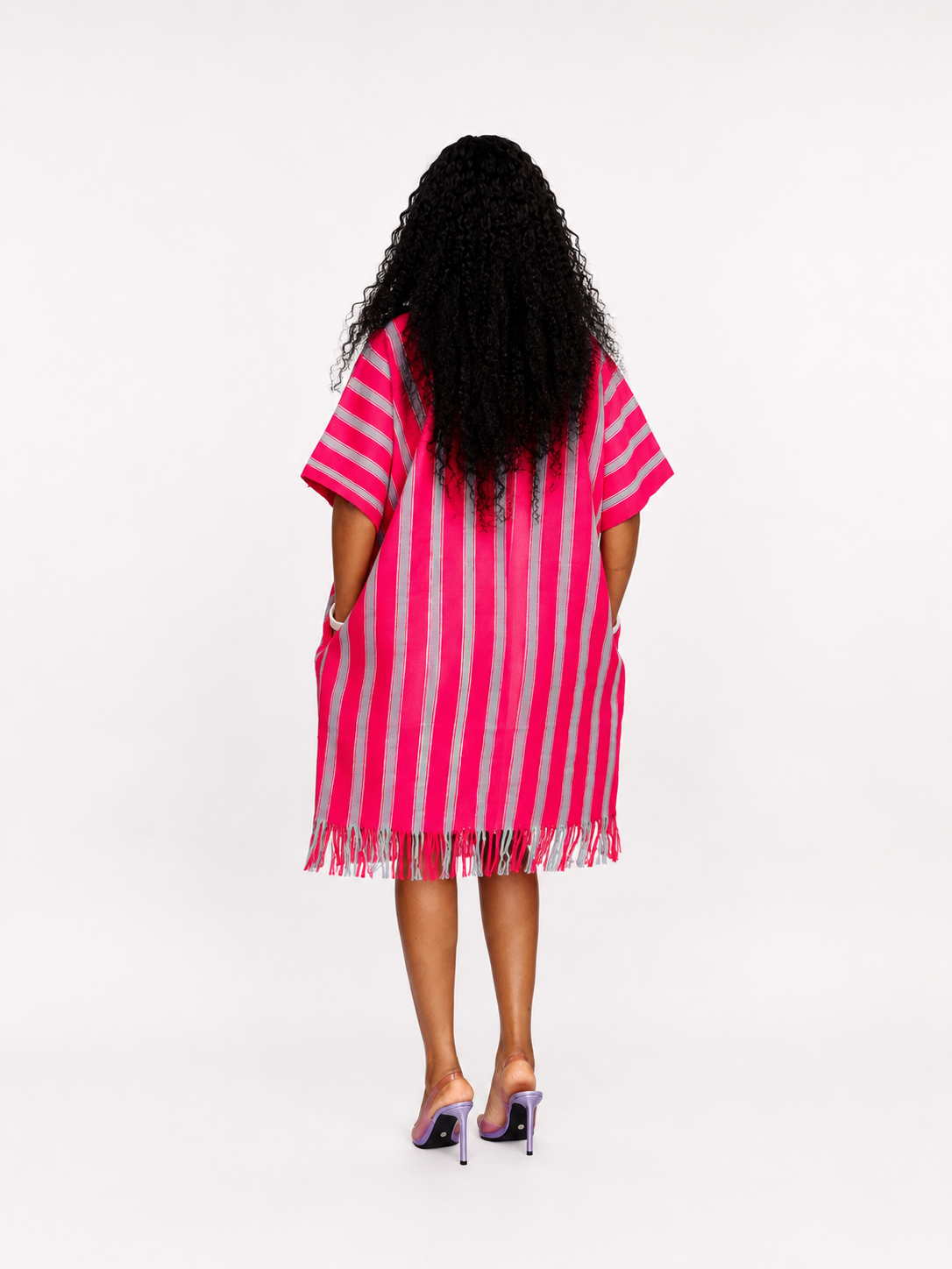 Side profile of a pink kaftan dress showing the length and fringe detail