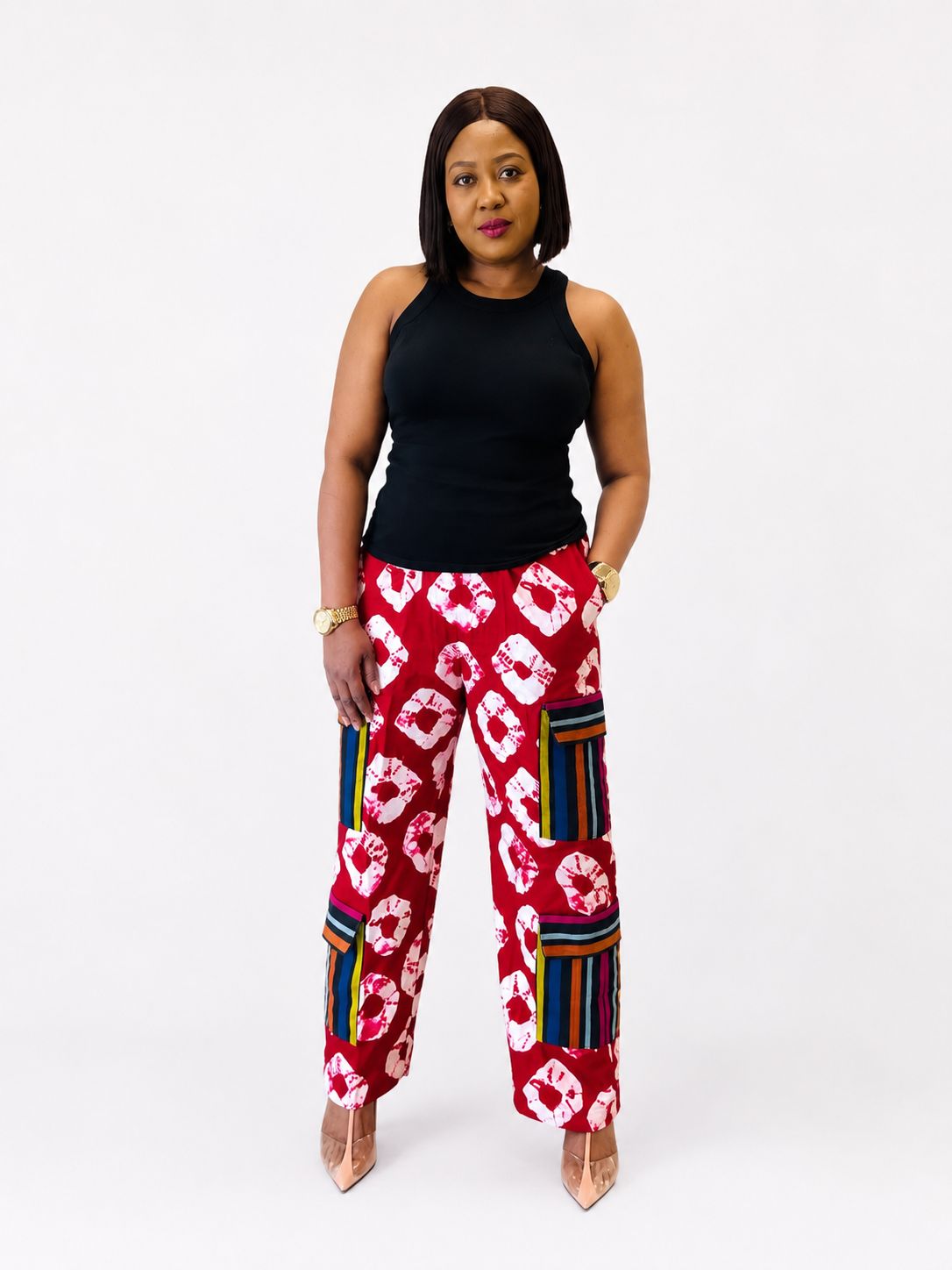 Front view of red tie-dye wide-leg cargo pants with striped side pockets.