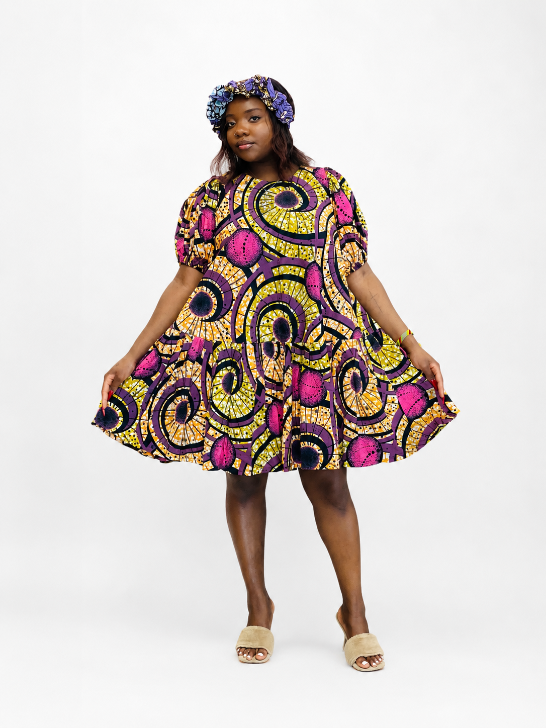 Front view of a yellow and purple geometric print tiered babydoll mini dress.