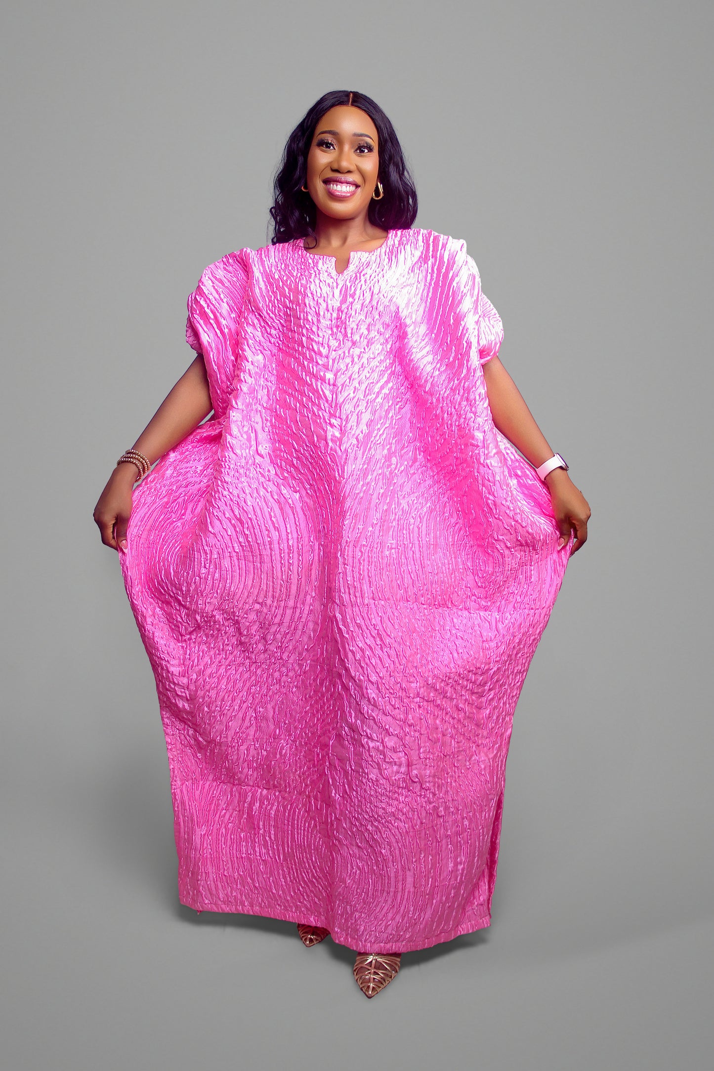 A front-facing view of the oversized pink textured kaftan showing its wide, comfortable sleeves and elegant drape.