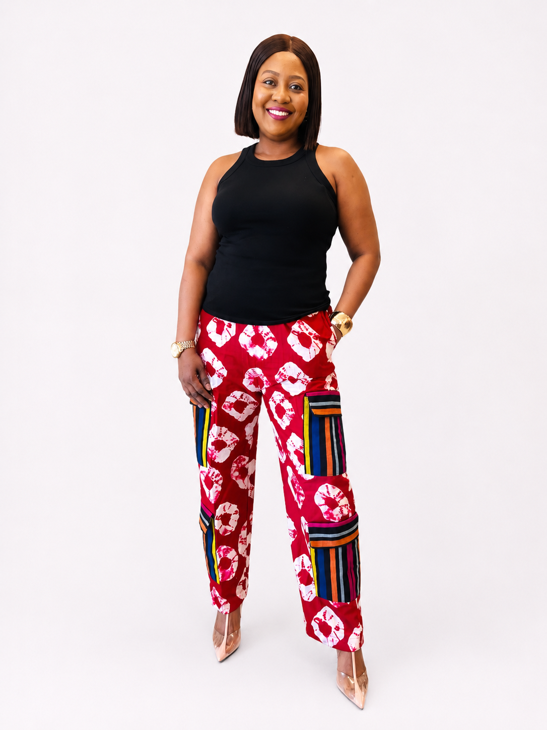 Front view of red tie-dye wide-leg cargo pants with striped utility pockets.