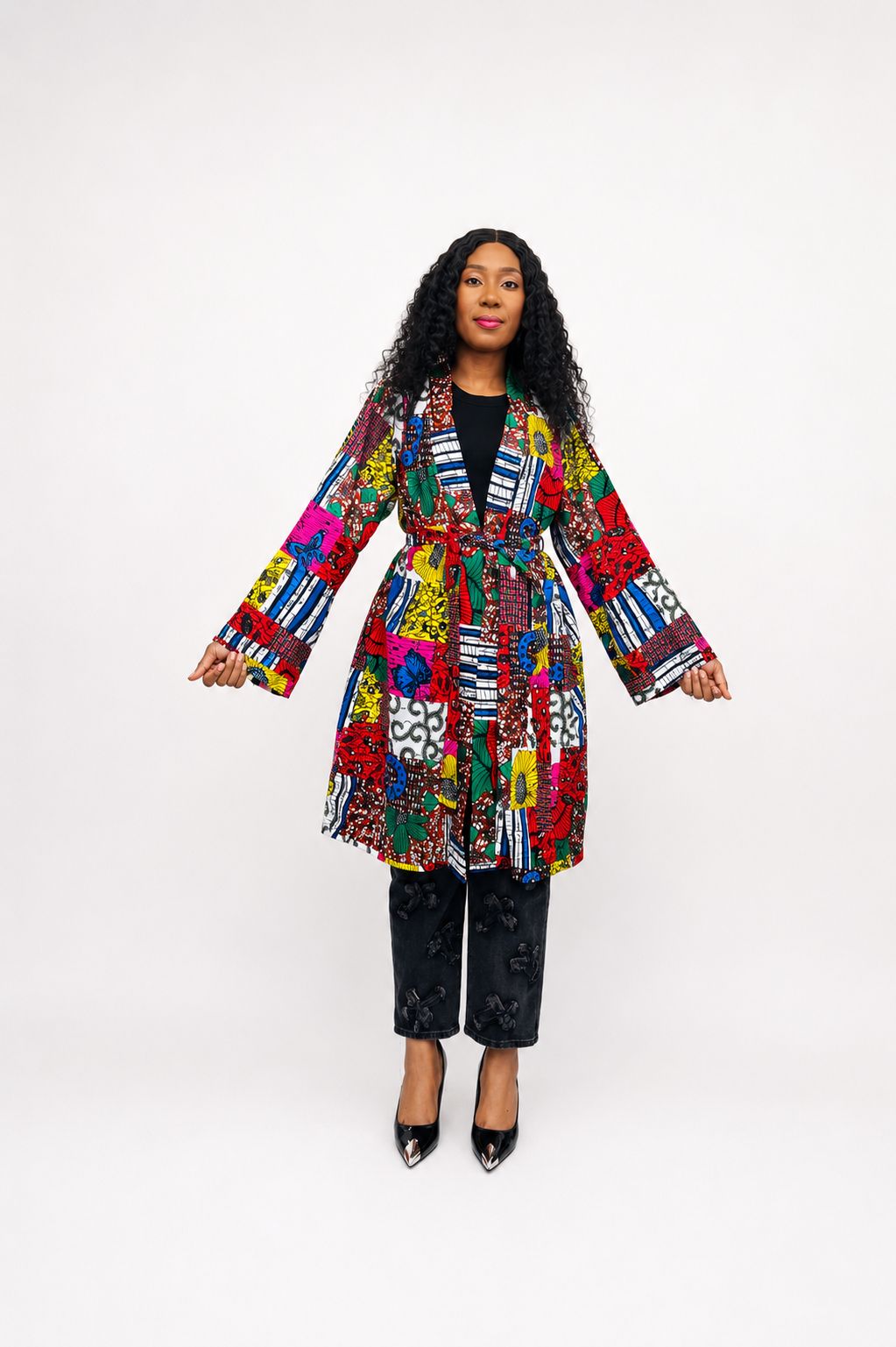Front view of the African print patchwork wrap coat tied at the waist, showing long sleeves and colorful patterned fabric.