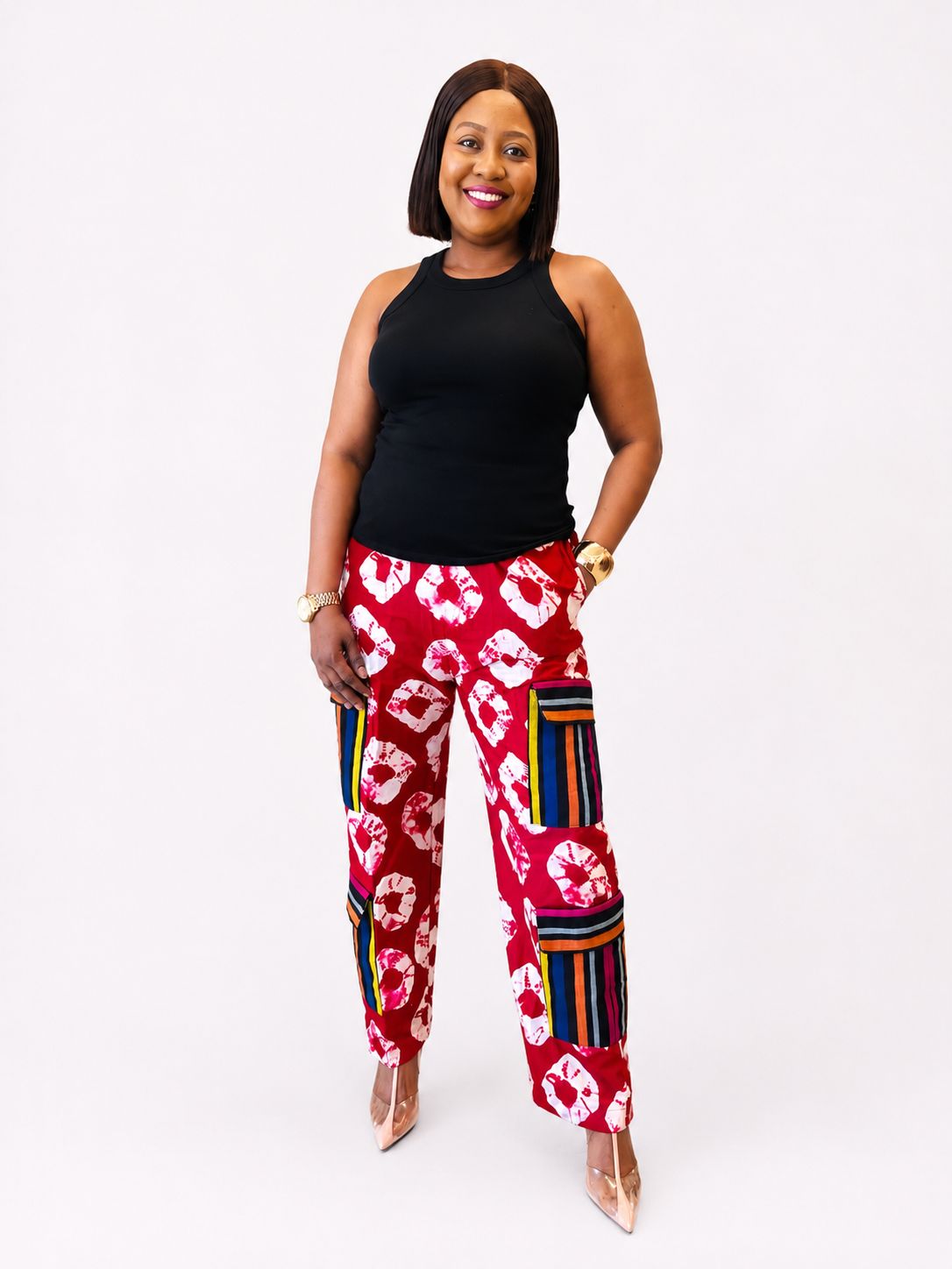 Front view of red tie-dye wide-leg cargo pants with striped utility pockets.